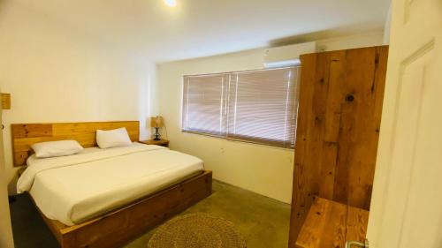 a small bedroom with a bed and a window at Wong village 106 in Tumbak Bayuh
