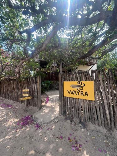 une clôture en bois avec un panneau indiquant wayapa dans l'établissement Casa Wayra, à Barra Grande