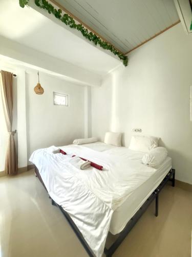 a bedroom with a large bed with white sheets at Private Room in Villa Near Nusa Dua Beach Bali in Nusa Dua