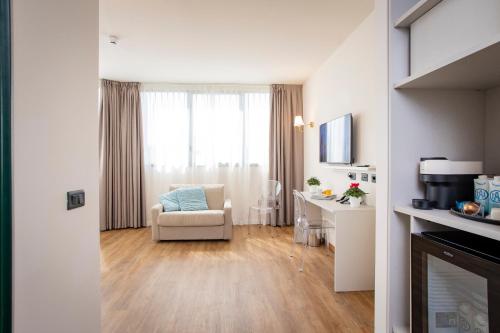 a living room with a chair and a desk at AN Hotel Milano San Donato in San Donato Milanese