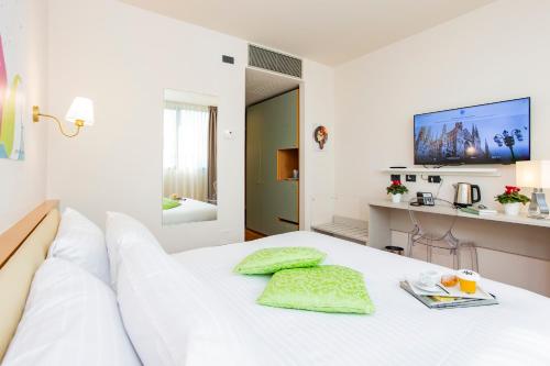a bedroom with a white bed with a tv on the wall at AN Hotel Milano San Donato in San Donato Milanese