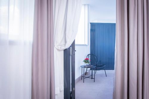 a room with a table and a window with a chair at AN Hotel Milano San Donato in San Donato Milanese