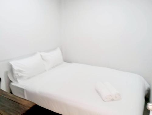 a white bed with white sheets and pillows at xx Mitr inn Khaosan มิตร อินน์ ถนนข้าวสาร in Bangkok