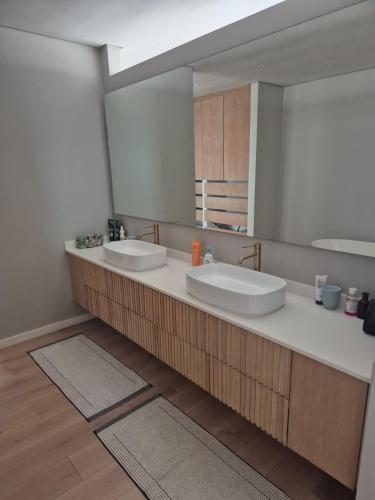 a bathroom with two sinks and a large mirror at Modern Luxury Beach Villa in Ballito
