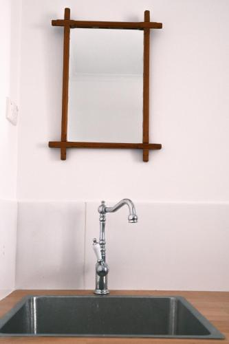 a kitchen sink with a wooden shelf above it at Blume Cottage 1860 in Stockwell