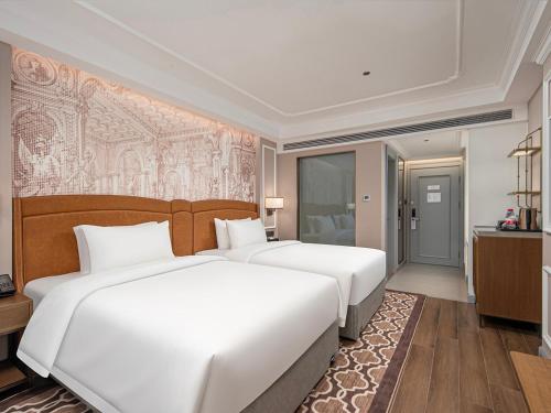 Ein Bett oder Betten in einem Zimmer der Unterkunft Vienna International Hotel--Free Shuttle Service to East Gate of forest park,Free Chinese-western Breakfast,Free Freah Coffee,Free Self-Service Laundry & Drying, Attraction Tickets Serivce in advance