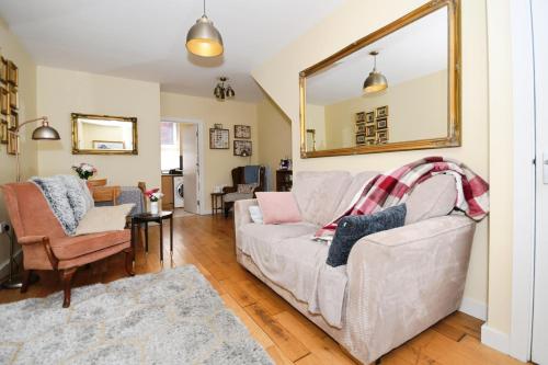 a living room with a white couch and a mirror at Kelham River View Home in Neepsend