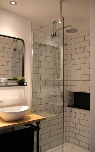 a bathroom with a glass shower with a sink at Hoeve Altena Barn-House in Woudrichem