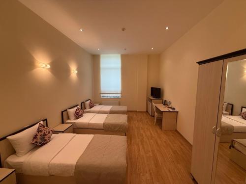 a hotel room with two beds and a window at Chukhur Gabala Museum Hotel in Gabala