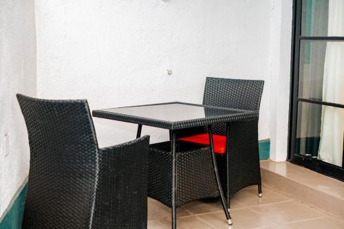 a black table and chairs in a room with a window at Ndare Eco Ville in Kigali