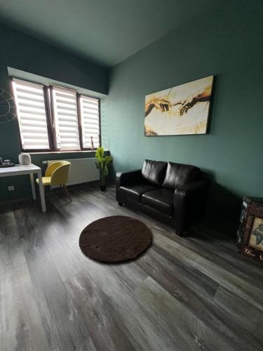 a living room with a black couch and a table at Smart Stay Porta Westfalica Zentrum in Porta Westfalica