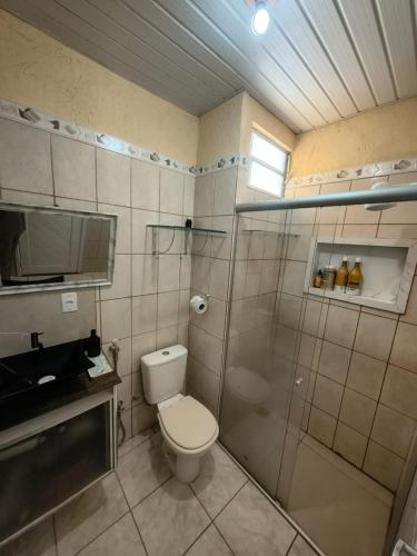 a bathroom with a toilet and a glass shower at Casa do Marco&Leoni in Belém