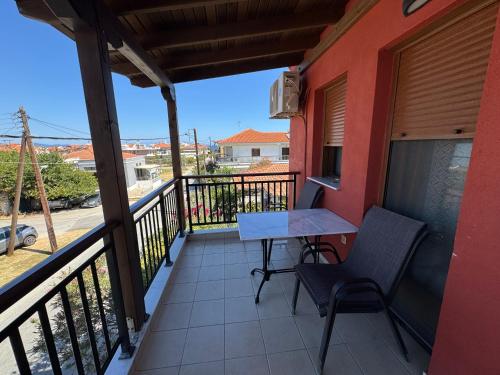 a balcony with a table and chairs on it at Nea Roda Apartments in Nea Roda
