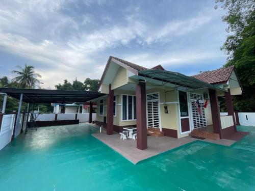 a villa with a swimming pool and a house at Sobey Laris Homestay Pasir Mas Town in Pasir Mas