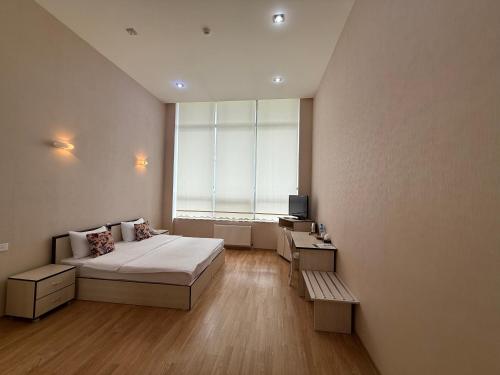 a bedroom with a bed and a large window at Chukhur Gabala Museum Hotel in Gabala