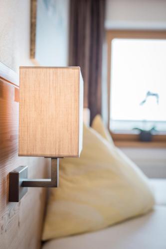 a lamp on the side of a bed at Alpenkönig in Zell am Ziller