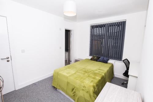 a bedroom with a green bed and a window at Stylish Ensuite Rooms, Middlesbrough TS5 in Middlesbrough