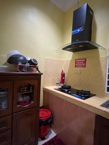 a kitchen with a stove and a counter top at Sobey Laris Homestay Pasir Mas Town in Pasir Mas