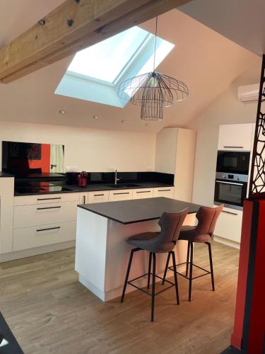 a kitchen with a table and chairs and a skylight at La petite maison in Sévérac d' Aveyron
