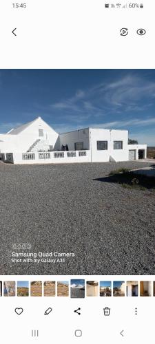 Un edificio blanco situado encima de una pila de grava. en Mesklip Caravan Park, en Springbok