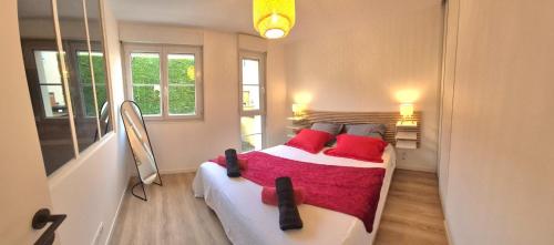 a bedroom with a bed with red pillows at Shanis - Cozy Appartement sur Pérouges-Meximieux in Pérouges