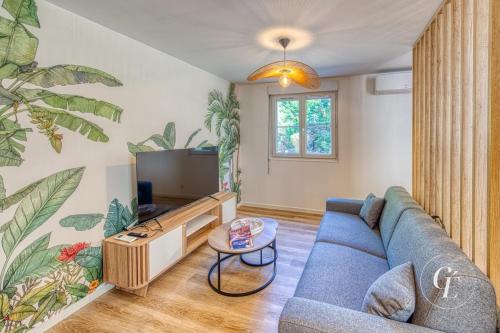 a living room with a blue couch and a tv at Shanis - Cozy Appartement sur Pérouges-Meximieux in Pérouges