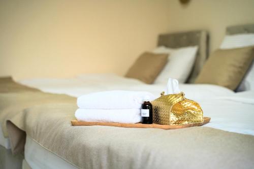 een dienblad met handdoeken en een fles wijn op een bed bij Villa LUXIA Luxury Holiday Retreat with Sauna & Fireplace outdoor lounge in Bihać
