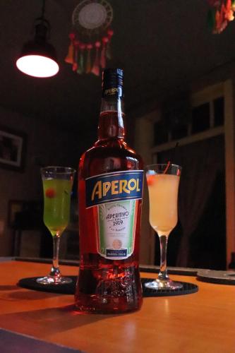 a bottle of alcohol and two glasses on a table at Hotel Brunette in Santa Ana