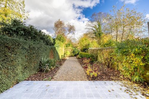 a path in a garden with a fence at Adorable maison 3ch proche de Bruxelles-Tervuren in Tervuren