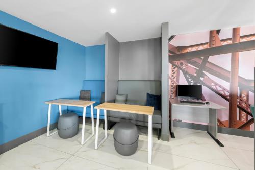 a room with two tables and a tv and a bridge at Clarion Pointe in Shreveport