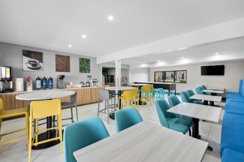 a restaurant with tables and chairs and a counter at Clarion Pointe in Shreveport