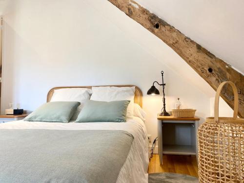 a bedroom with a bed with a wooden headboard at Maison Onze calme en bord de Rance in Plouër-sur-Rance