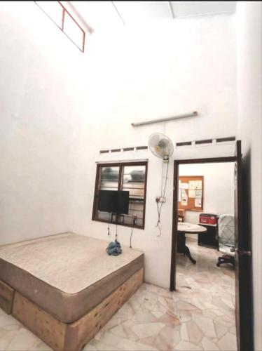 a bedroom with a bed with a window and a desk at 欢唱名宿 in Kluang