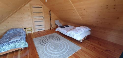 a room with a bed and a chair in a attic at Agroturystyka AKPólko in Biała Podlaska