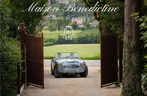 a couple in a car driving through a gate at Maison Benedictine in Caprino Veronese
