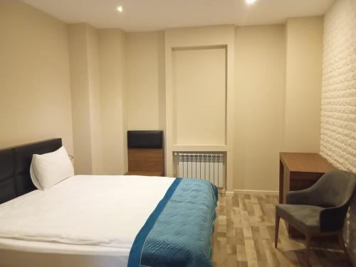 a bedroom with a bed and a chair and a desk at Briiz Hotel Baku in Baku