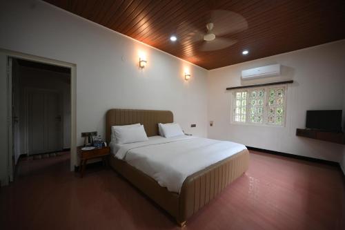 a bedroom with a large bed and a window at Tinton Adventure Resort in Golikatte