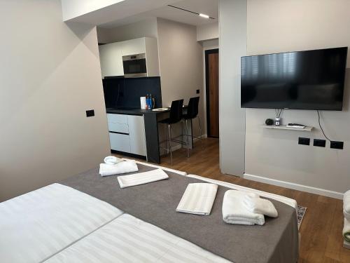 a hotel room with a bed and a flat screen tv at Renev Apartments Tirana in Tirana