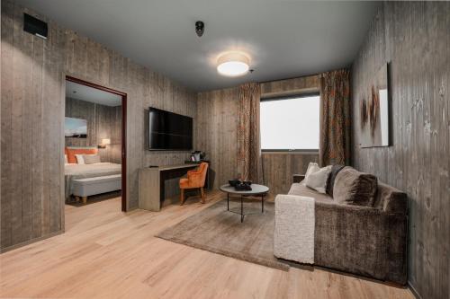 a living room with a couch and a bedroom at Pellestova Hotell Hafjell in Hafjell