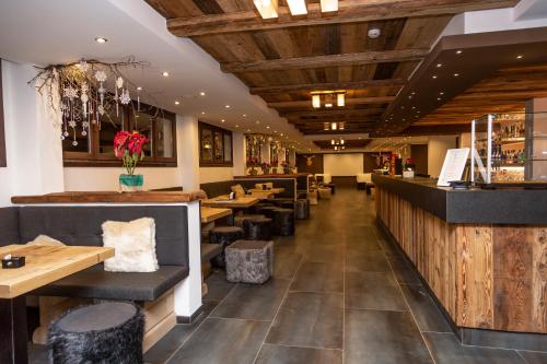a restaurant with wooden ceilings and tables and chairs at Hotel Gran Roc in Sestriere