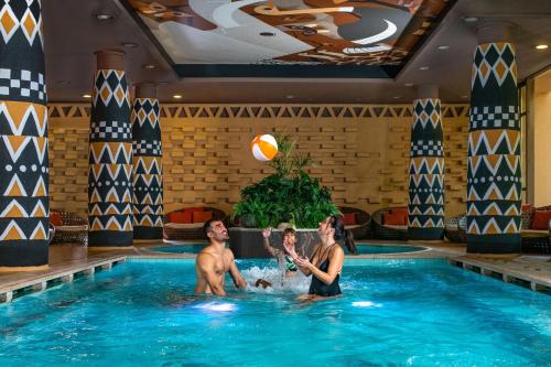 a man and woman playing in a swimming pool at Bambara Hotel in Felsőtárkány