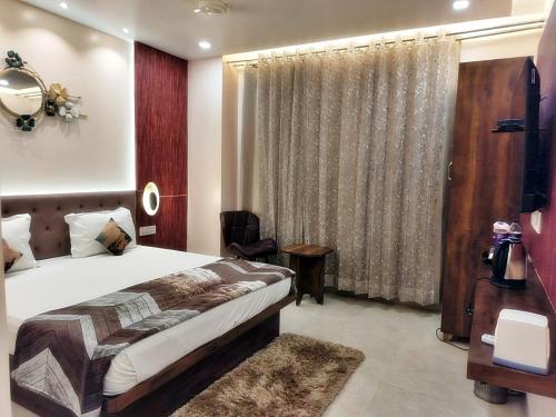 a bedroom with a bed and a large window at Hotel Luxuria in Ludhiana
