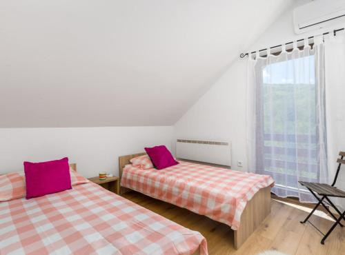 a bedroom with two beds and a window at Holiday Home Elizabeta in Slunj