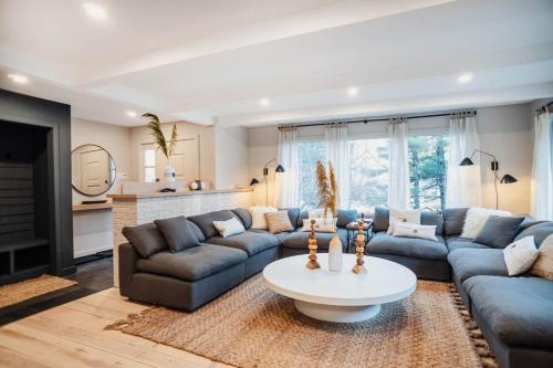 a living room with blue couches and a table at Catskill MNTN Escape 5 BR 3 bath Villa Hot Tub Fire Pit Best Group Stay in Prattsville