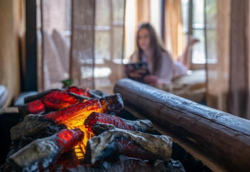 a woman looking at her cell phone over a fire at Bambara Hotel in Felsőtárkány