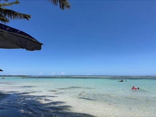 un groupe de personnes dans l'eau sur une plage dans l'établissement Santo Domingo Tropical Peaceful Escape Ocean Front Near Boca Chica Airport, à La Golondrina