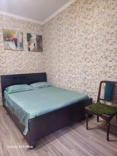 a bedroom with a bed and a chair at Luka in Tbilisi City