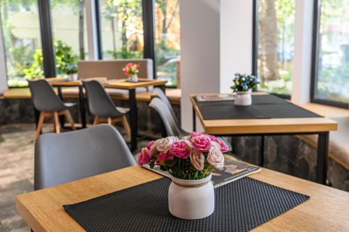 a vase with pink flowers sitting on a table at Johann Strauss Hotel in Bucharest