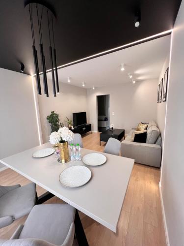 a living room with a white table and chairs at Apartment BEIGE Exclusive in Piekary Śląskie