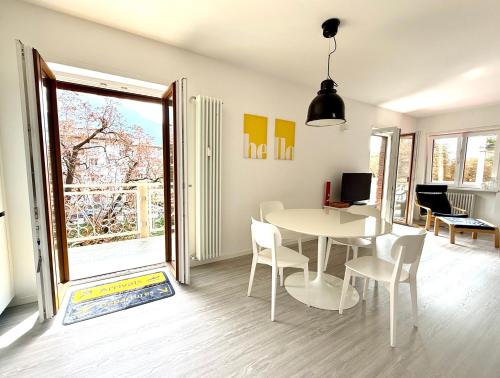 een eetkamer met een witte tafel en stoelen bij Domus Fersina in Trento